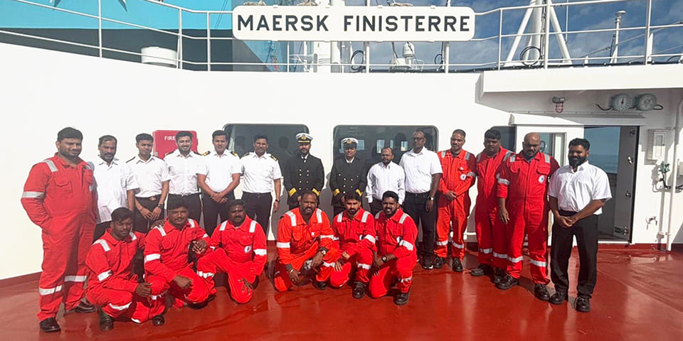 Group photo of the Maersk Finisterre crew in uniform and boiler suits, representing maritime operational readiness and team competence